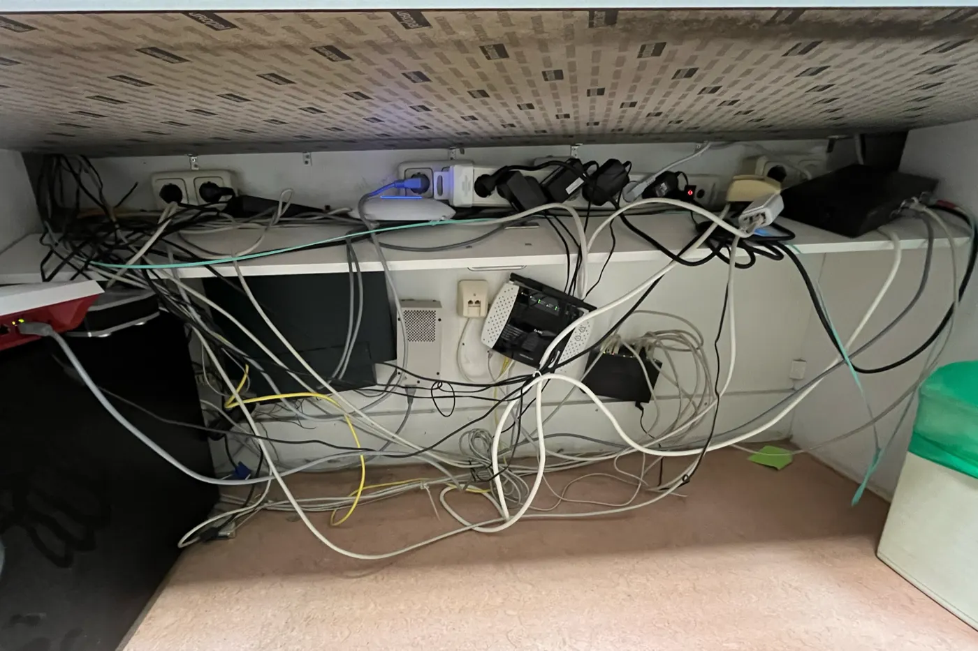 Vorher: lose Kabel, Netzteile und Netzwerkgeräte unter einem Schreibtisch